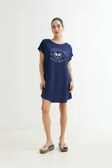 Vestido corto color verde oliva con estampado de dos rostros en color blanco.