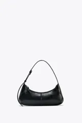 Bolso de hombro negro de cuero sintético, con asa ajustable con hebilla metálica, bolsillo interior con cremallera y cierre principal con cremallera.