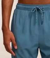 Bermuda deportiva azul con short de compresión interno, cintura elástica con cordón ajustable y bolsillo trasero con cierre.