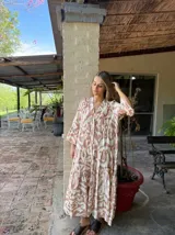 Vestido midi con estampado abstracto en tonos beige y marrón, con cuello en V, mangas 3/4 y corte escalonado.