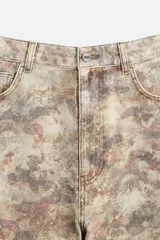 Pantalón de jean de corte recto con estampado abstracto en tonos beige, marrón y gris.