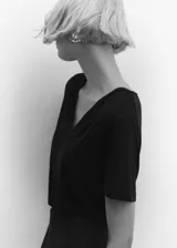 Remera blanca de corte recto, con cuello en V y mangas cortas.