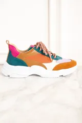 Zapatillas deportivas con paneles de cuero, gamuza y malla en colores naranja, marrón, verde, lila y crema. Cordones gruesos multicolor y suela chunky blanca.