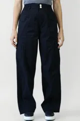 Pantalón negro de tiro alto, corte palazzo y bolsillos laterales.