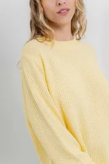 Sweater azul de punto medio, amplio, suave, con escote a la base y puños en mangas y en acabado inferior.