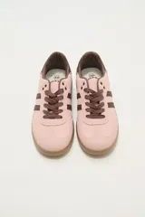 Zapatillas deportivas color rosa con detalles en marrón, cordones marrones y suela color caramelo.