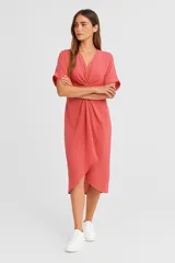 Vestido midi color salmón, de lino y algodón, con escote en V, mangas cortas y corte irregular.