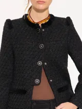 Chaqueta corta de jacquard chanel color celeste, con cuello redondo y cierre frontal con botones marrones. Presenta detalles de flecos en el escote, bolsillos delanteros inferiores y sisas.