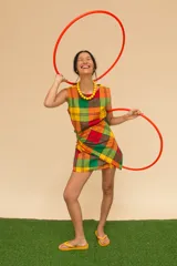 Vestido corto sin mangas con estampado de cuadros en tonos azul, rojo, verde y blanco. Tiene cuello redondo y ruedo con flecos.