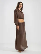 Blusa corta celeste de tejido arrugado liviano, con cuello mao, botones al frente, mangas abullonadas y ruedo elastizado.