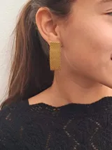 Par de aros colgantes rectangulares color dorado, con diseño tejido tipo rejilla.