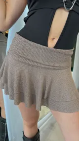 Minifalda marrón de tiro bajo, con volados en el ruedo.