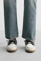 Zapato náutico de cuero blanco con detalles en negro y suela marrón. Edición limitada con horma redonda y plantilla de cuero.