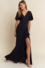 Vestido largo de fiesta color azul marino, con escote en V con detalle de encaje, mangas cortas con abertura y falda con tajo lateral y volados.