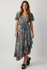 Vestido midi estampado con motivos paisley en tonos azul, gris y naranja. Tiene escote en V, mangas cortas con volados, cintura elastizada con lazo y falda asimétrica con volados.