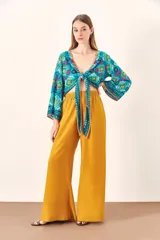 Pantalón palazzo color mostaza, de tiro alto y corte holgado.