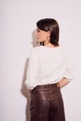 Remera color crema de algodón peinado, con mangas 3/4 abullonadas y corte ajustado al cuerpo.