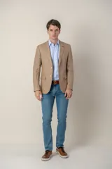 Saco de lino color beige, corte slim fit, con solapa de muesca, cierre de dos botones, bolsillo en el pecho y dos bolsillos delanteros con solapa. Medio forro.