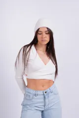 Remera corta gris de punto con escote cruzado y mangas largas.