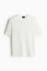 Remera blanca de algodón con tejido de punto calado, cuello redondo y corte estándar.