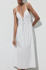 Vestido midi blanco de popelín con escote pico pronunciado, tirantes finos ajustables con cordones y detalle de frunces en la cintura.