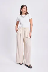 Pantalón de lino color beige, de corte palazzo, con cintura elastizada y cordón ajustable.
