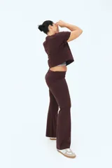 Pantalón marrón de punto suave con cintura ancha plegable y piernas rectas con bajo acampanado.