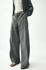Pantalón palazzo color gris topo de tejido fluido, con cintura elástica ajustable con cordones y bolsillos laterales.