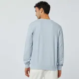 Sweater celeste de punto piqué con cuello redondo y mangas largas.