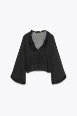 Camisa negra con escote en pico y manga larga abullonada. Detalle de volantes en el mismo tejido.
