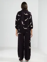 Pantalón palazzo color beige con estampado de girasoles marrones en el ruedo.