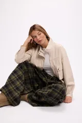 Pantalon de corte oversize y tiro medio, confeccionado en tela con estampado de cuadros en tonos marrones y negros. Presenta una silueta amplia y holgada con cintura elástica y cordón ajustable.