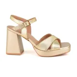 Sandalias de cuero color beige con plataforma y taco cuadrado. Presentan tiras cruzadas en el empeine y pulsera con hebilla al tobillo.