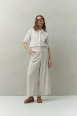 Pantalón palazzo color crema, de tiro medio con cintura elastizada en la parte posterior. Confeccionado en mezcla de lino y viscosa.