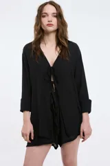 Camisa beige de mangas largas con lazo frontal y cuello en V.