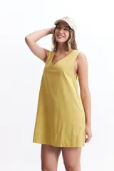 Vestido corto color amarillo mostaza, de corte recto y escote en V, sin mangas. Confeccionado en algodón.