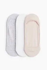 Pack de tres pares de soquetes invisibles de punto fino en mezcla de algodón suave, diseñados para quedar ocultos en el calzado. Tienen reborde de silicona en el interior del talón para un ajuste óptimo. Incluye un par color gris, uno blanco y uno rosa pálido.