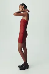 Vestido mini rojo de cuero sintético, con escote corazón y hombros descubiertos.