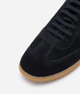 Championes negros de gamuza con suela de goma color caramelo y detalle blanco en el talón.