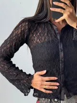 Camisa de encaje negra con cuello clásico y botones frontales.
