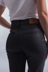 Pantalón negro de corte recto, tiro alto y efecto engomado.