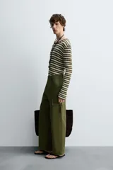 Pantalón cargo verde oliva de corte relaxed fit, confeccionado en tejido de algodón compacto con estructura twill. Cuenta con bolsillos frontales, traseros de vivo y bolsillos plastrón con solapa en las perneras.