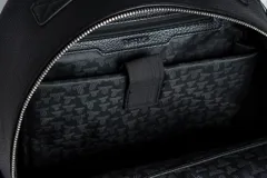 Mochila negra de cuero sintético con logo grabado en el frente, asa de mano y correas acolchadas ajustables.