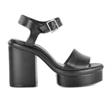 Sandalias negras de cuero sintético con plataforma y taco cuadrado alto. Tira ancha sobre los dedos y pulsera con hebilla al tobillo.