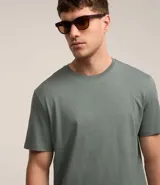 Remera de hombre color verde grisáceo, de manga corta y cuello redondo, confeccionada en algodón peruano.