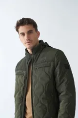 Campera de nylon color verde militar, con capucha, cierre frontal con cremallera, bolsillos laterales y frontales.