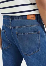 Pantalón de jean azul oscuro, corte slim con elastano.