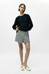 Falda pantalón corta de tiro alto con estampado pata de gallo, corte cruzado y cierre lateral con cremallera oculta.