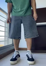 Bermuda de jean gris oscuro con lavado gastado, corte ancho y largo a la rodilla.