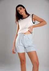 Blusa blanca de crochet calado, sin mangas y con cuello redondo con ribete negro.